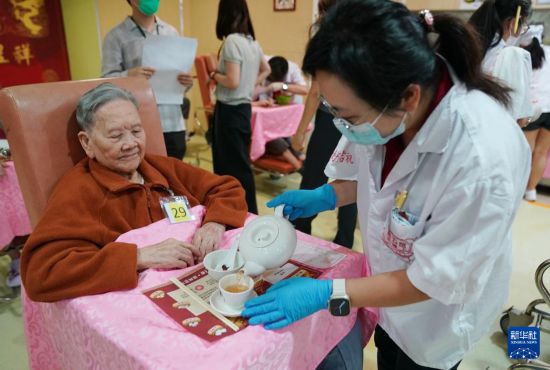 5月24日，在香港松悦园耆和护养院，身穿白衫的伙计在“茶楼”售卖茶点，端茶倒水。新华社发（王申 摄）